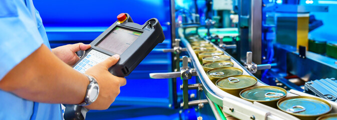 Manager check and control automation canned food products on conveyor belt in distribution...