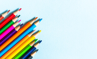 Many different colored pencils. Color pencil. Pencils are sharp. Pencils placed diagonally in the upper-right corner. Close-up. Copy space. Background. Flatlay