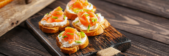 Smorrebrod or sandwich with Ricotta and salmon  on the cutting board.