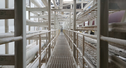 Walk way with  handrail have cable ladder and steam pipe inside  pulp industial