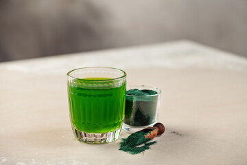 Glass of spirulina drink powder on table. Food and drink, dieting and nutrition concept.