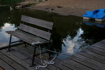 Fototapeta na wymiar wooden bench on the pier on the lake