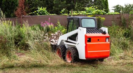 A skid steer loader clears the site for construction. Land work by the territory improvement....