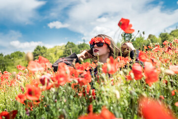 young woman in hat walk at poppy field pick flowers