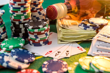 Dollar bills, casino chips and whisky glass on table. Gambling game concept.