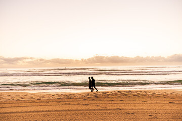 Fototapeta na wymiar 2 people men jogging on the beach in early morning Gold Coast Australia