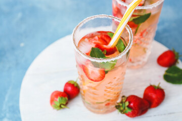 Fototapeta na wymiar Glass of tasty strawberry mojito on color background