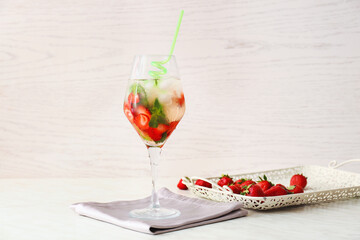 Glass of tasty strawberry mojito on table