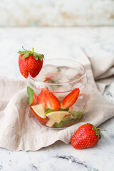 Glass of tasty strawberry mojito on table