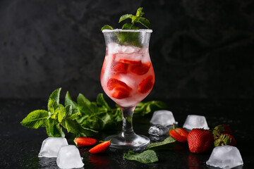Glass of tasty strawberry cocktail on dark background