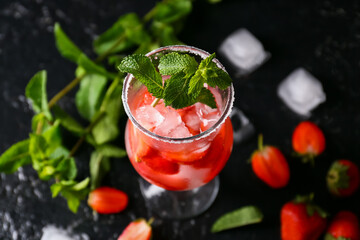 Glass of tasty strawberry cocktail on dark background