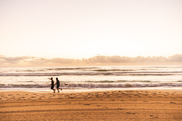 Fototapeta na wymiar 2 men jogging on the beach in early morning Gold Coast Australia