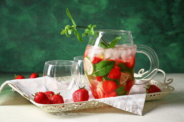 Jug of tasty strawberry mojito on tray