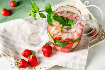 Jug of tasty strawberry mojito on tray