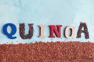 Word QUINOA with seeds on color background