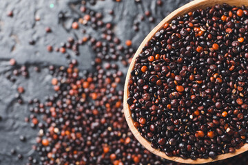 Spoon with healthy quinoa on dark background, closeup