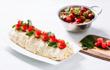 Delicious meringue roll with strawberry on table