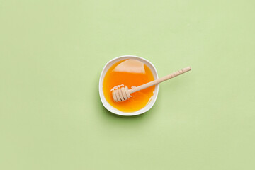 Bowl with honey on color background