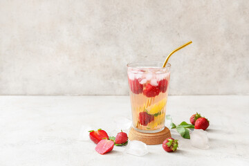 Glass of tasty strawberry cocktail mojito on light background