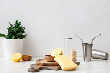 Wooden utensils with sponge and lemon on table in kitchen. Ecology concept