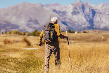Fototapeta na wymiar Senior man on hike through beautiful countryside in autumn.