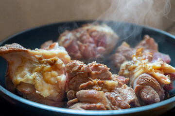 Smoking cuts of meat in a frying pan. The process of cooking meat.