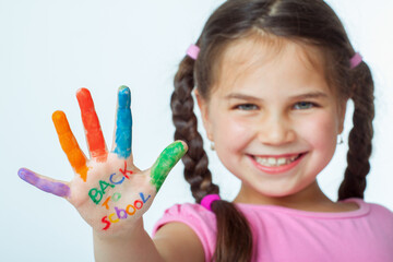 Beautiful little girl with her hands full of paint