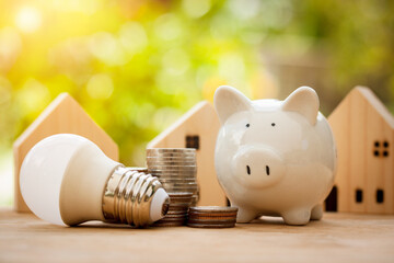 Energy saving and money concept, Piggy bank with light bulb and stack of coins for new house in the...