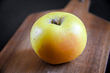 Apple on wooden cutting board