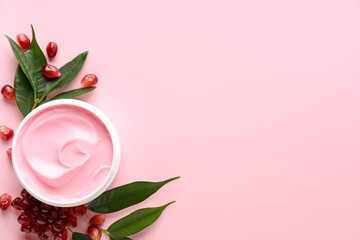Fresh pomegranate and jar of facial mask on pink background, flat lay. Space for text
