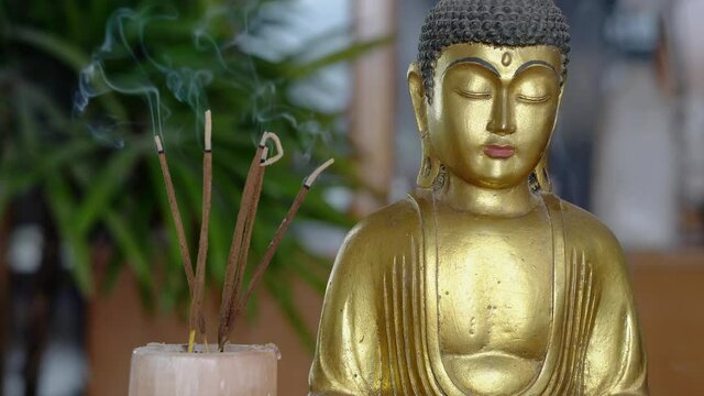 Golden Indian Buddha with buring Incense