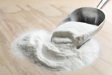 Baking soda in scoop on wooden table