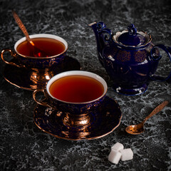 Vintage tea pair with teapot on a black background