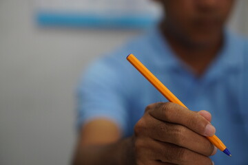 A picture of a man with a pen writing close up.