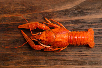 Delicious boiled crayfish on wooden table, top view