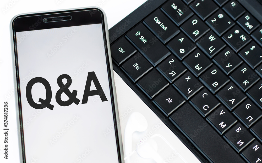 Poster q and a text in the phone lying on the laptop keyboard