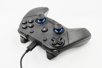 Gamepad with cable on a white background. Game Joystick. Closeup, selective focus