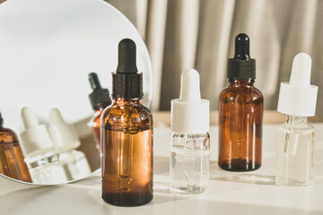 Spa cosmetics in brown glass bottles on a white table. Beauty blogger, salon therapy, branding layout, minimalism concept. Top view, copy space