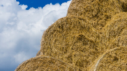Haystack close up. Hay bale against a blue sky. Harvesting hay, dry grass
