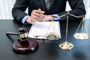 Professional male lawyers work at a law office There are scales, Scales of justice, judges gavel, and litigation documents. Concepts of law and justice
