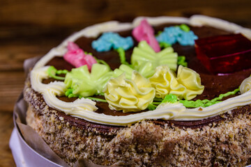 Kiev cake with cream, nuts and meringue in cardboard box on a wooden table