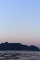 Vertical photo of sea and hills in dusk. Traveling to nature