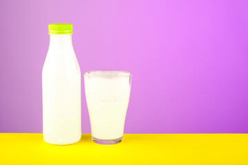 bottle and glass with dairy product on yellow table