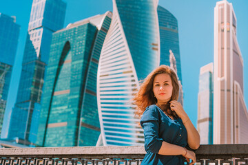 Beautiful business woman in a dress on the background of glass skyscrapers, business theme of business successful people