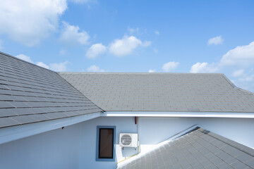 Slate roof against blue sky, Gray tile roof of construction house with blue sky and cloud © tong2530