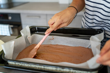 Obraz premium Female hands lays out chocolate dough on a baking sheet, hobby and entertainment, food concept