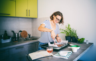 Beautiful happy young woman preparing dessert at home lays out dough on a baking sheet, hobby and entertainment, food concept