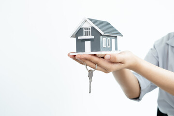 The hand of the real estate agent holding the house model and the keys Loan and home concept