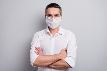 Portrait of his he nice attractive healthy content mature guy wearing safety mask stop pandemia contagious viral pneumonia respiratory influenza disease isolated light gray pastel color background