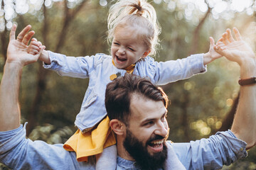 happy father and daughter playing while walking in a beautiful autumn park. Ideal weekend father...